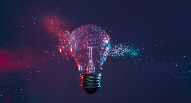 High speed studio photography, moment of the impact of a bullet on a classic electric bulb. Detail of glass explosion, blue and purple lighting. Concept of obsolete energy.