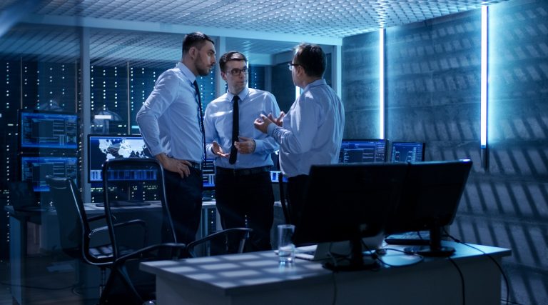 três funcionários discutem em um data center