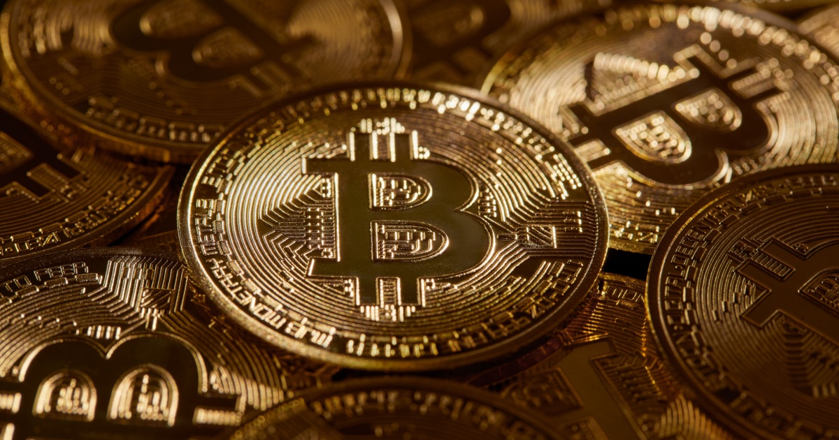Imagem de moedas físicas de Bitcoin com design dourado, dispostas umas sobre as outras, refletindo a luz em seus detalhes e símbolos criptográficos (criptomoedas, Silvergate Bank, bitcoin)