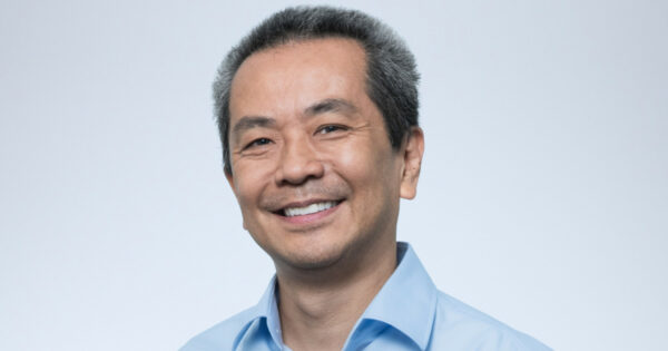 Helio Matsumoto, novo Chief Technology Officer (CTO) LATAM da Rimini Street, sorrindo em uma foto profissional. Ele veste uma camisa azul clara, com fundo branco, transmitindo uma expressão amigável e confiante (Helio Matsumoto, Sicredi, Grupo Fleury)
