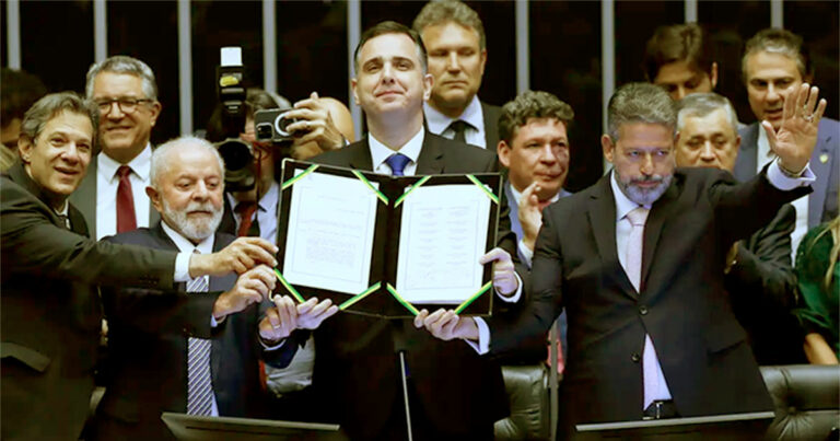 Rodrigo Pacheco ergue, ao lado de Lula, Fernando Haddad e Arthur Lira, a Emenda 132, promulgada em 20 de dezembro - Foto: Lula Marques/Agência Brasil
