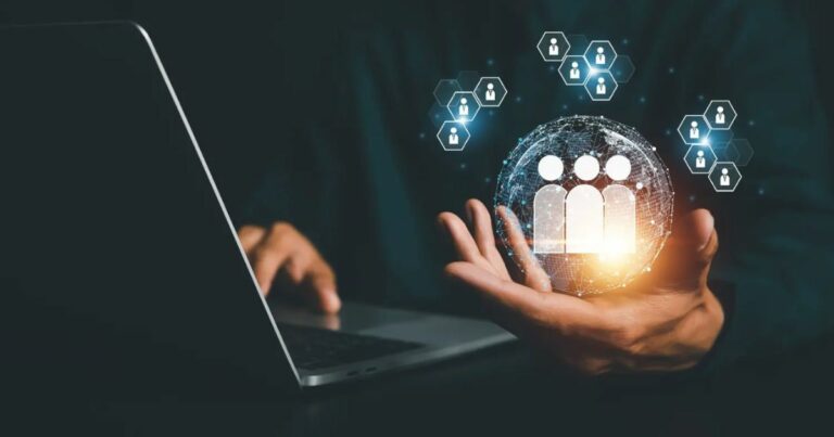 Imagem de uma pessoa utilizando um notebook, com uma mão segurando uma esfera digital brilhante contendo ícones de pessoas. Ao redor da esfera, há pequenos ícones de cadeados e perfis, representando conceitos de gestão de pessoas, recursos humanos e segurança de dados. (rh, recursos humanos, gestão de pessoas, hrtechs, RH, totvs)