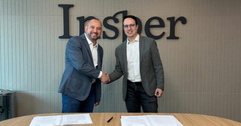 Bruno Rocha, representante da TCS Brasil, e Guilherme Martins, presidente do Insper, apertando as mãos em frente ao logo do Insper, simbolizando uma nova parceria ou acordo formal. Ambos estão sorrindo, transmitindo um clima de cooperação e sucesso. Na mesa à frente, há documentos assinados e canetas, representando a formalização do compromisso