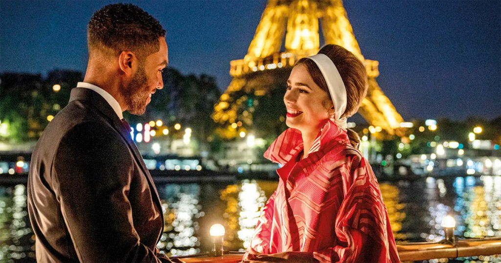 Alfie (Lucien Laviscount) e Emily (Lily Collins), com a torre Eiffel ao fundo, em cena de “Emily em Paris” (Imagem: Divulgação)