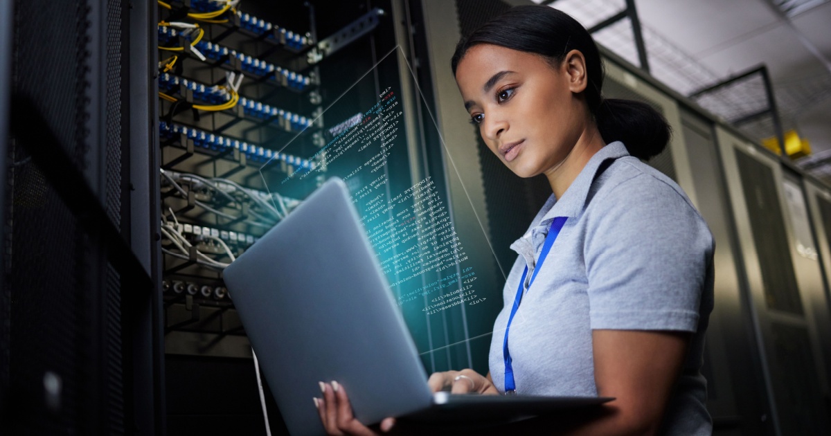 Mulher trabalhando em um data center, analisando informações em um laptop enquanto está cercada por servidores e cabos de rede. A tela do laptop exibe códigos ou dados, e ela parece concentrada, destacando um ambiente tecnológico e de alta segurança (trabalhadora, funcionária, mulher, rede, data center, networking, Cisco, infra )