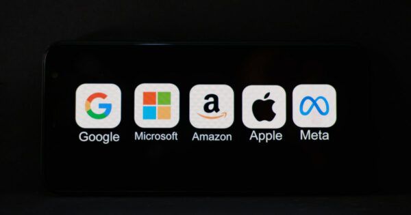 "Imagem mostrando ícones e nomes das principais empresas de tecnologia: Google, Microsoft, Amazon, Apple e Meta, exibidos em uma tela preta. Representação das chamadas 'Big Techs'