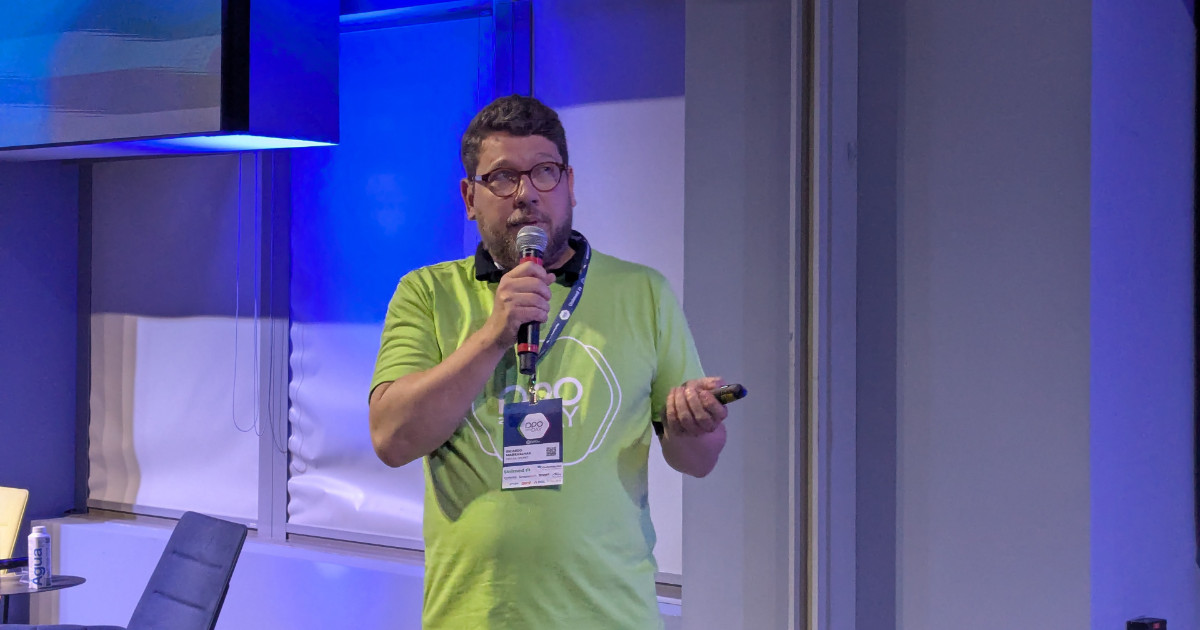 Ricardo Maravalhas, CEO da DPOnet, apresentando durante um evento, segurando um microfone e usando uma camiseta verde com o logotipo da empresa
