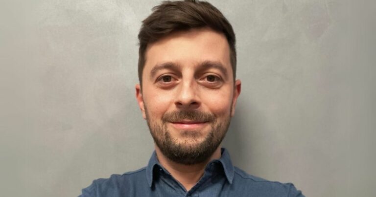 Retrato de Caio Galantini, diretor executivo e cofundador da HVAR. Ele está sorrindo levemente, tem barba curta e cabelo castanho penteado para o lado. Veste uma camisa azul e posa diante de um fundo neutro e levemente texturizado (Google Cloud)