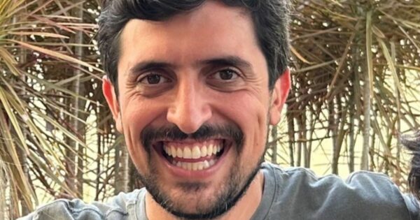 Homem branco sorrindo para a foto