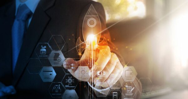 A imagem mostra um homem de terno tocando uma interface digital holográfica com elementos gráficos relacionados a tecnologia e finanças. No centro, um ícone de foguete iluminado simboliza o lançamento de um novo projeto ou startup. Ao redor, hexágonos exibem ícones e textos relacionados a blockchain, pagamentos digitais, criptomoedas e assinaturas eletrônicas. A cena transmite uma sensação de inovação, investimentos em tecnologia e crescimento acelerado, temas comuns no universo de venture capital (venture capital, vc, startups, aportes, investimentos, equity, CloudWalk, assin, venture hub, cvc)