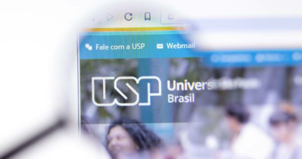 Imagem mostra a tela de um computador com o site da Universidade de São Paulo (USP) aberto. Em destaque, o logotipo da USP e os textos "Universidade de São Paulo", "Brasil", "Fale com a USP" e "Webmail", com ícones correspondentes. A imagem está levemente ampliada, com o canto superior esquerdo da tela em foco e partes desfocadas ao redor (sistema)