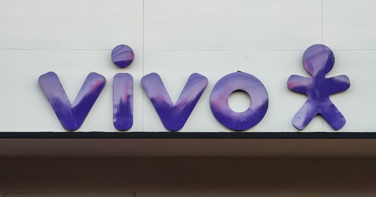 Logótipo da operadora de telecomunicações "Vivo" em letras minúsculas, com tipografia arredondada na cor roxa com reflexos rosados. À direita da palavra, está o símbolo da marca: uma figura humana estilizada com braços e pernas abertas, também em roxo., solução, telefónica (Actionline)