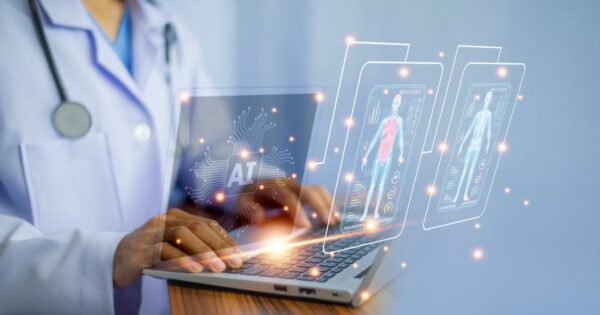 Pessoa vestida com jaleco branco e estetoscópio, presumivelmente um profissional de saúde, utiliza um laptop. Na tela, há um símbolo de “AI” (inteligência artificial) com circuitos ao redor. Projetados no ar à frente do computador, aparecem hologramas de exames médicos digitais com imagens do corpo humano, incluindo sistemas muscular e esquelético, acompanhados de gráficos e indicadores. A cena transmite o uso de inteligência artificial na medicina, com foco em tecnologia avançada para diagnóstico ou análise clínica. (saúde, google, pesquisa, hcor, bionexo, sensor)