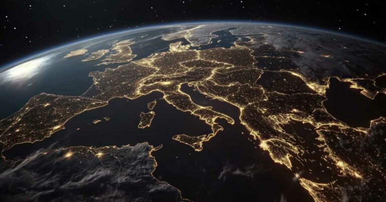 Imagem da Europa vista do espaço durante a noite, com as luzes das cidades iluminando o continente e destacando as principais regiões urbanas. A cena transmite a ideia de conectividade, tecnologia e desenvolvimento urbano, com destaque para países como Itália, França, Alemanha e Reino Unido.