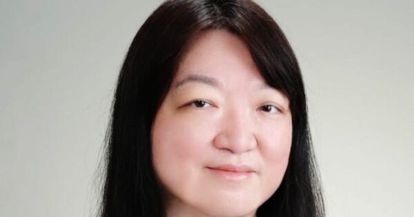Retrato de uma mulher com cabelos lisos, longos e pretos, repartidos levemente para o lado. É a Vera Okabayashi, nova CIO Latam do Schindler Group. Ela tem pele clara, olhos escuros e está sorrindo suavemente, com expressão serena. O fundo é neutro, em tom claro e uniforme.