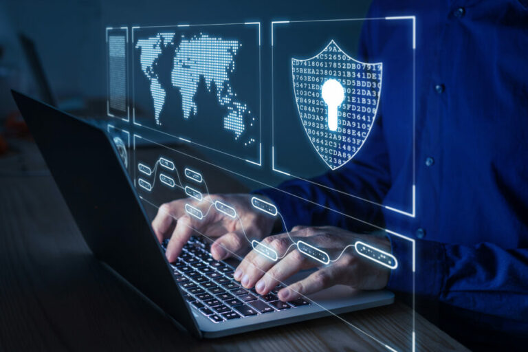 Pessoa usando laptop com gráficos digitais de segurança cibernética, tecnologia de proteção digital e mundo digital, destacando segurança da informação (CIO, Brasil, saúde)