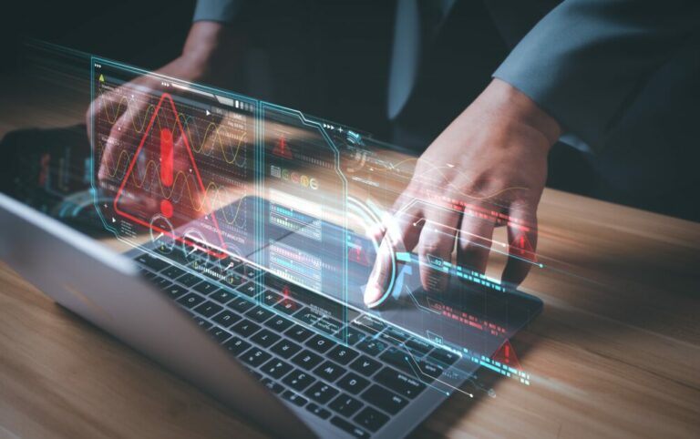 Imagem de um profissional de cibersegurança monitorando sistemas e monitorando alertas em uma tela holográfica, destacando a importância da proteção digital.