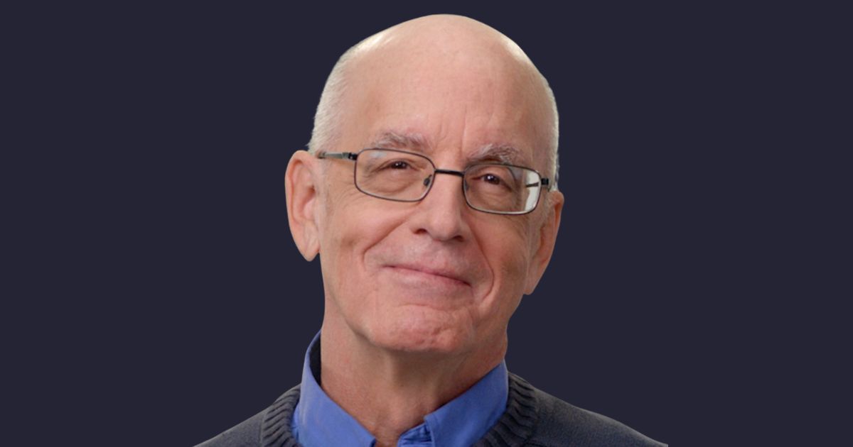 Homem idoso calvo, de pele clara e óculos, sorri levemente em frente a um fundo escuro. Ele veste camisa azul e suéter cinza. Na imagem, está Gary Bolles, especialista globalmente reconhecido em inteligência artificial e seus impactos no futuro do trabalho, aprendizado e organizações, IT Forum Praia do Forte