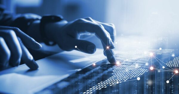 A imagem mostra um close das mãos de uma pessoa digitando em um teclado de laptop. Sobre a cena, há gráficos digitais com nós e linhas interconectadas, sugerindo conexões de dados ou redes. O fundo em tons de azul reforça uma atmosfera tecnológica e futurista. (IA, impacto, Praticx, personalização, gestão)
