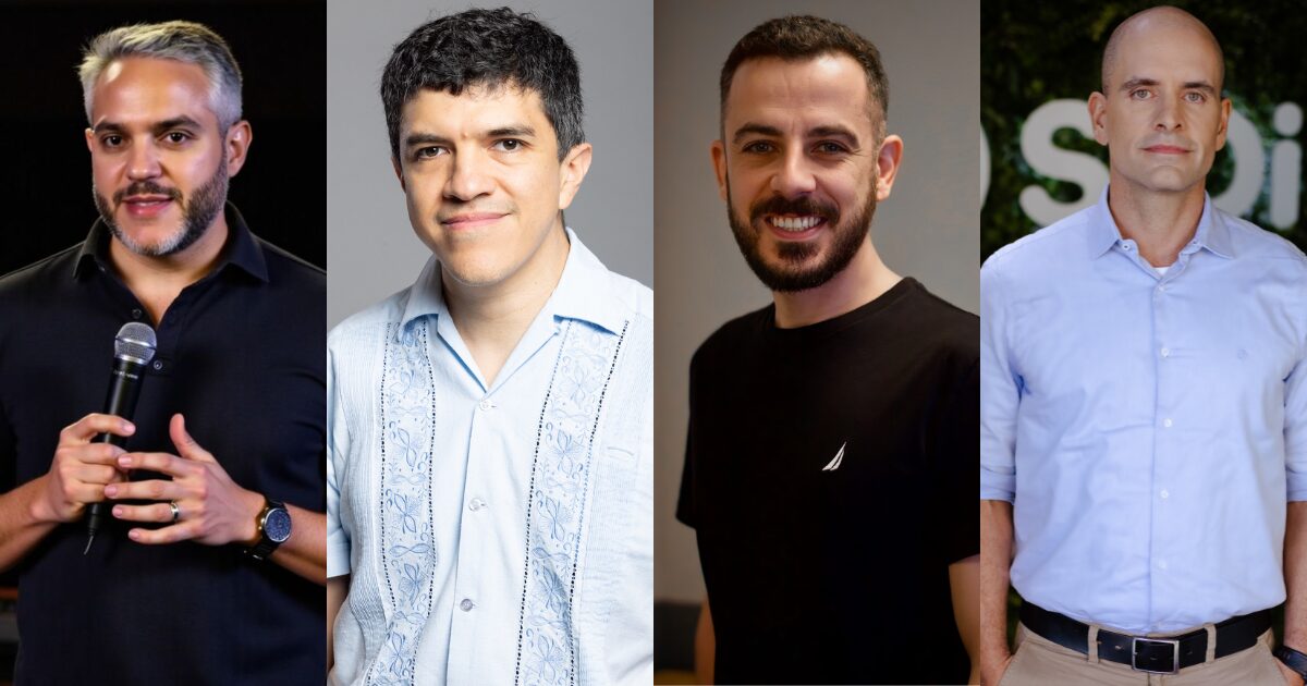 Quatro homens estão em pé lado a lado. O primeiro, à esquerda, segura um microfone e veste uma camisa preta. O segundo usa uma camisa azul clara com padrões detalhados. O terceiro está com uma camiseta preta lisa, e o quarto veste uma camisa social azul clara com calça bege. (vibe coding)