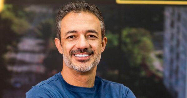 O CEO da OmniChat, Mauricio Trezub, está usando uma camisa azul. Ao fundo, é possível ver uma cena ao ar livre com árvores e edifícios. Não há texto ou outros elementos visuais adicionais na imagem.