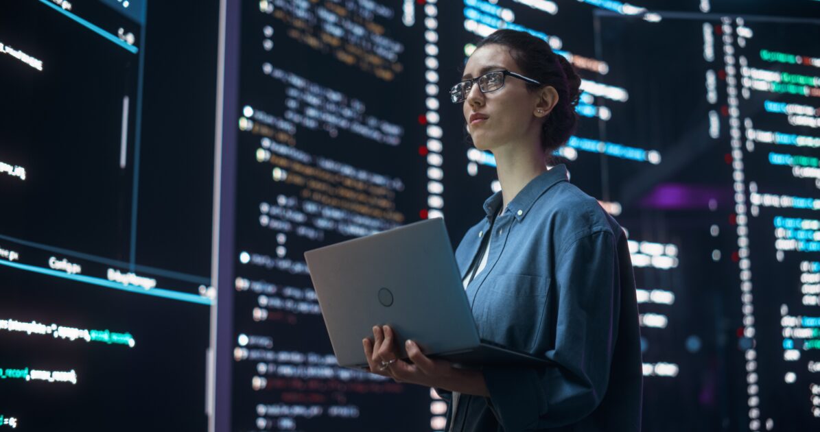 Pessoa de óculos segurando laptop enquanto analisa códigos e dados em ambiente tecnológico e de segurança digital, multimodais, software, quantica