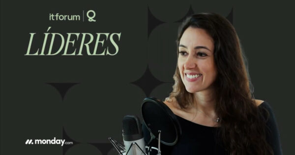 Mariana Gaida, head de People da Uncover, sorrindo em frente a um microfone durante gravação, com fundo escuro que traz os logos do It Forum Líderes e da monday.com.