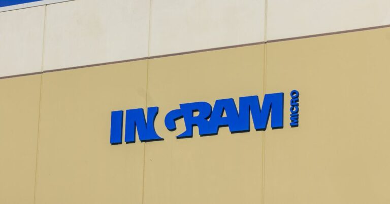 Fachada de um prédio comercial com o logotipo da empresa "Ingram Micro" em destaque. O nome da empresa está escrito em letras maiúsculas azuis, fixado na parte superior da estrutura, indicando a presença da marca no local. (BRLink)