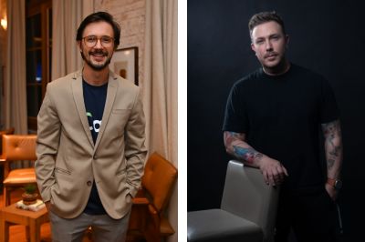 Homem de blazer bege Pessoa usando blazer bege sobre uma camiseta azul marinho estampada. Está em um ambiente interno com cortinas claras e poltronas de couro ao fundo. 3. Pessoa com camiseta preta e braços tatuados Pessoa vestindo camiseta preta, apoiada em uma cadeira clara. Os braços exibem várias tatuagens coloridas, e o cenário possui iluminação suave, com fundo escuro.
