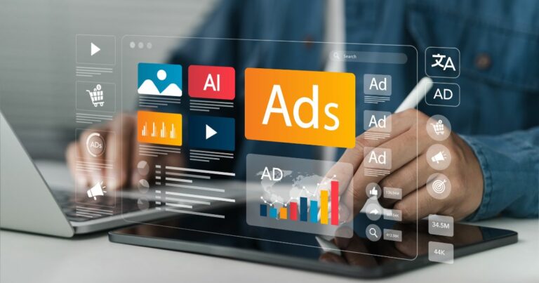 Uma pessoa trabalha em um tablet sobre uma mesa, enquanto diversos elementos gráficos de interface flutuam acima da tela, representando ferramentas e opções de publicidade digital. Entre os ícones aparecem ‘Ads’, gráficos de desempenho, elementos de vídeo, carrinho de compras, símbolos de idioma e indicadores numéricos. Ao fundo, um notebook permanece aberto, contribuindo para o ambiente tecnológico.