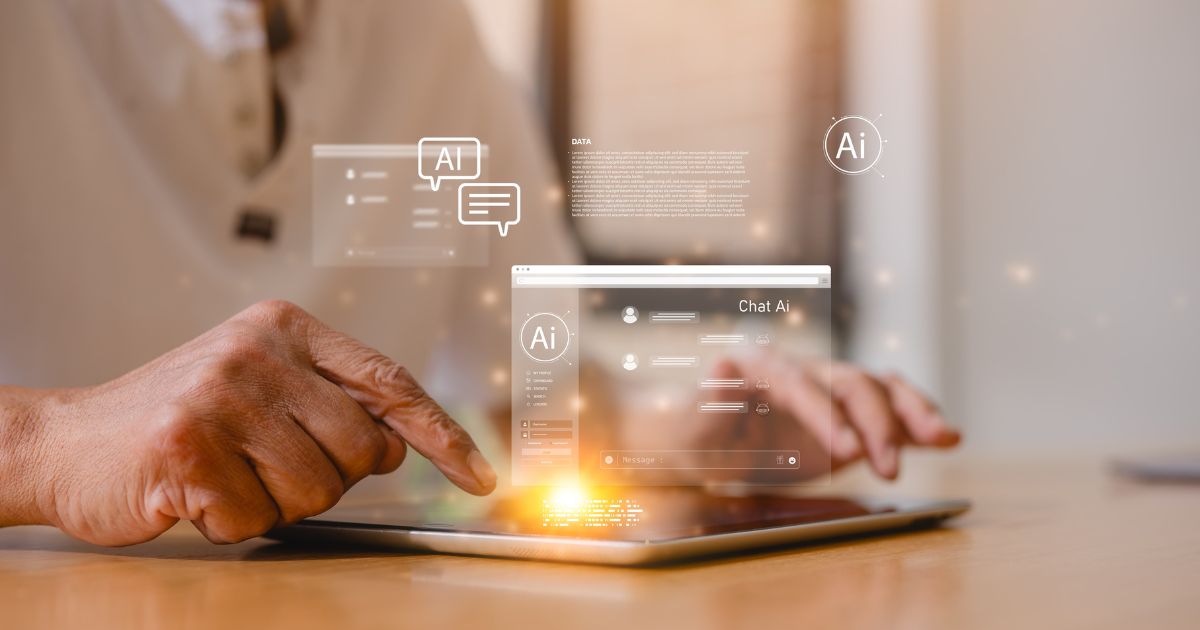 A imagem mostra uma mão interagindo com um tablet apoiado sobre uma superfície de madeira clara. Sobre a tela do dispositivo aparecem elementos gráficos digitais em estilo holográfico, incluindo janelas de interface, ícones circulares com a sigla “AI”, caixas de diálogo e um layout que simula um sistema de chat com inteligência artificial. A iluminação é quente, entrando pela lateral, criando reflexos suaves no tablet. O cenário transmite a ideia de tecnologia avançada e interação com ferramentas digitais.