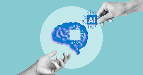 A imagem mostra duas mãos interagindo com uma ilustração conceitual sobre inteligência artificial. No centro, há um desenho de um cérebro em tons de azul e rosa com um quadrado branco no meio, sugerindo processamento digital. Uma das mãos segura um ícone azul com a sigla ‘AI’ cercado por pequenos circuitos, enquanto a outra mão aparece abaixo em um gesto de apoio. O fundo é azul‑claro com um grande círculo branco ao centro, reforçando o tema tecnológico e abstrato. (cognitiva)