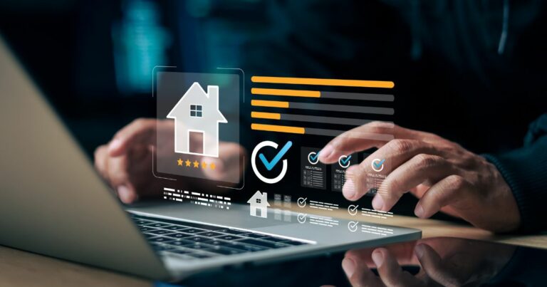 A imagem mostra uma pessoa utilizando um laptop em uma mesa, enquanto elementos gráficos digitais aparecem projetados acima do teclado. Entre os ícones visíveis há a silhueta de uma casa com cinco estrelas abaixo, um grande símbolo de verificação dentro de um círculo e diversos blocos de informações em formato de cartões. Barras horizontais coloridas, caixas de seleção marcadas e pequenos indicadores visuais compõem a interface. O ambiente é escuro, iluminado principalmente pelo brilho azulado da projeção digital e da tela do laptop, reforçando um clima tecnológico e moderno. (serviço)