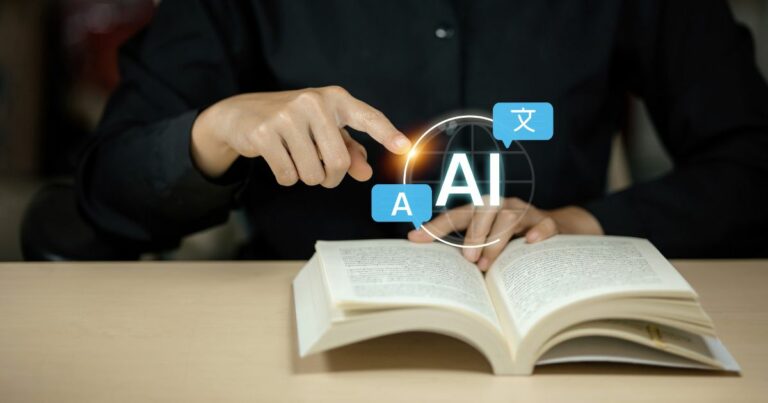 Pessoa sentada à mesa com um livro aberto à sua frente. Uma das mãos aponta para um elemento gráfico sobreposto ao livro, com a sigla ‘AI’ no centro de um círculo luminoso. Ao redor da sigla aparecem pequenos ícones de balões de texto com caracteres, sugerindo tradução ou processamento de linguagem. O fundo é escuro e desfocado, destacando o livro, as mãos e o elemento digital. (alfabetiza)