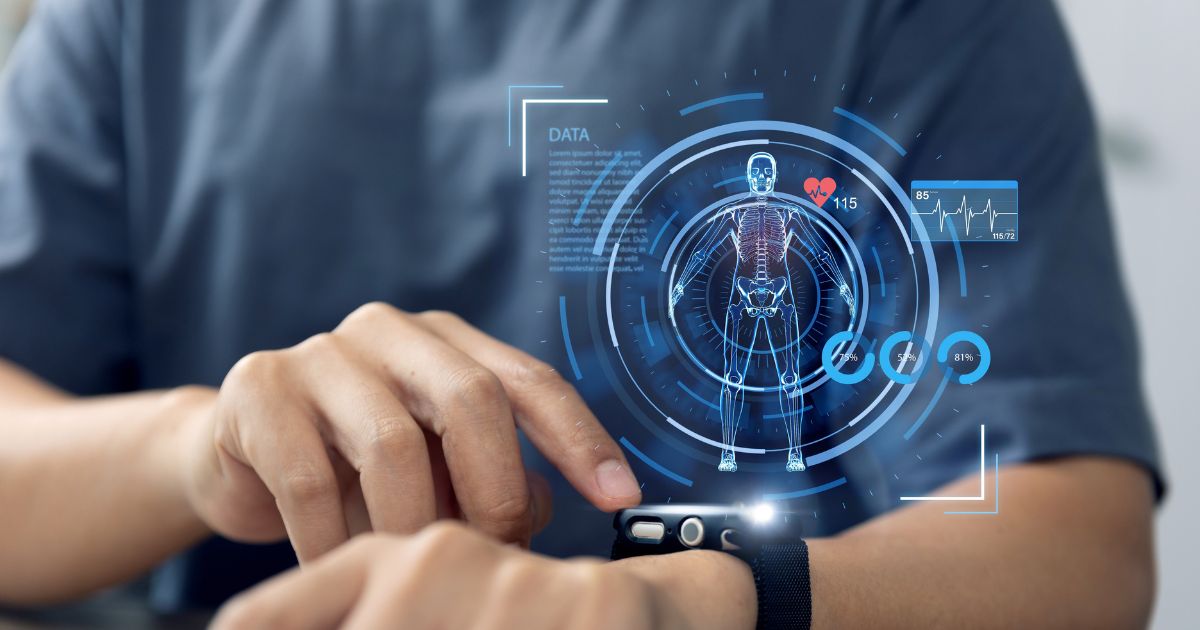 Pessoa utilizando um smartwatch no pulso, tocando a tela com o dedo indicador da outra mão. Sobreposta à imagem, há uma interface digital em tons de azul com a representação de um corpo humano em estilo wireframe, destacando o esqueleto. Ao redor, aparecem gráficos circulares, barras de progresso, ícones e um monitoramento de frequência cardíaca com números como ‘115’. O fundo é desfocado, com foco no braço, no relógio e nos elementos visuais, sugerindo tecnologia wearable e acompanhamento de dados de saúde.