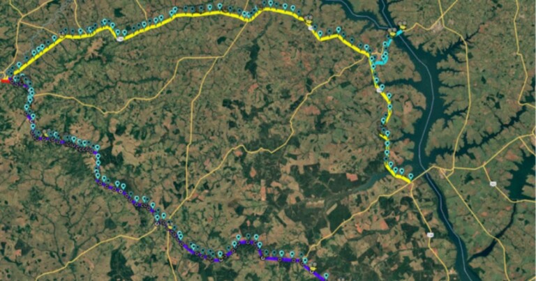 Mapa de satélite mostrando um trecho rodoviário monitorado pela TIM Brasil e pelo Grupo Way Brasil, com rota destacada em amarelo e diversos pontos de cobertura geolocalizados ao longo da estrada. A imagem exibe a extensão da conectividade em uma região predominantemente rural, com rios, vias de acesso e áreas de vegetação ao redor.