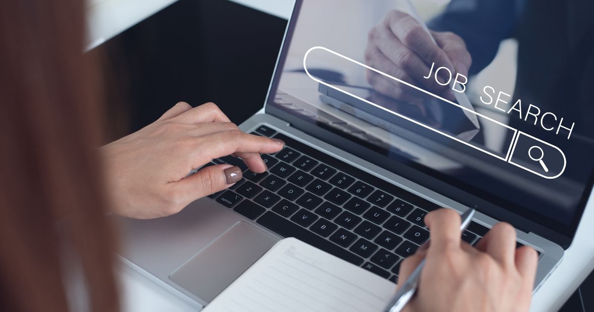 Pessoa utilizando notebook para pesquisar vagas de emprego online, com barra de busca exibindo o termo “Job Search” na tela, representando recrutamento, candidatura a empregos e oportunidades de carreira.