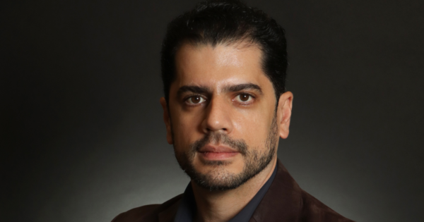 Diego Miranda, novo gerente de Inovação e Produto da Apdata, posa para foto institucional com expressão séria, cabelos escuros penteados para trás e barba curta, vestindo blazer marrom-escuro sobre camisa preta. Ao fundo, aparece um cenário de estúdio em tons de cinza e preto, com iluminação direcionada ao rosto do executivo. Miranda assume a responsabilidade de conectar tecnologia, inteligência artificial e análise de dados ao desenvolvimento de soluções para gestão de pessoas. (Diego Miranda, Apdata, Inovação e Produto, Liderança, Inteligência Artificial, Tecnologia, Gestão de Pessoas)