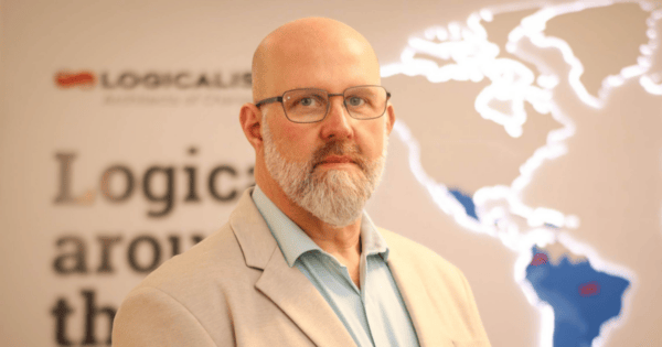 Paulo Torres, novo diretor de Tech & Solutions da Logicalis Brasil, posa para foto institucional usando óculos, camisa azul-clara e blazer bege. Ao fundo, aparecem a identidade visual da Logicalis e um mapa iluminado das Américas. O executivo assume a liderança das estratégias de pré-vendas, arquitetura de soluções e evolução do portfólio de serviços da companhia no Brasil. (Paulo Torres, Logicalis Brasil, Tech & Solutions, Liderança, Tecnologia, Transformação Digital)